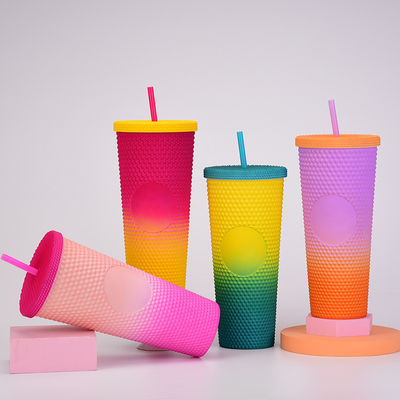 Une tasse de café à double paroi en plastique iridescent mat, avec paille.